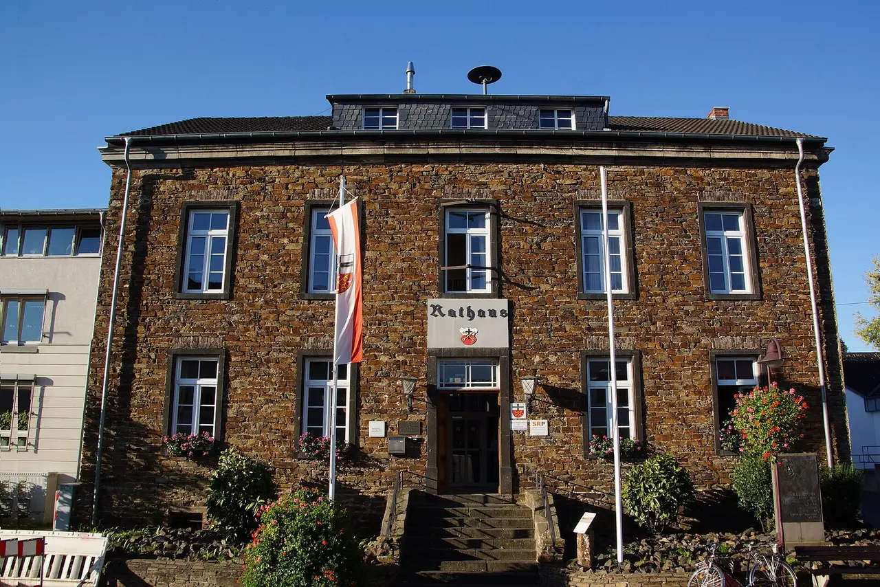 Bruchsteinfassade des Alten Rathauses Unkel mit Freitreppe und Fahnen