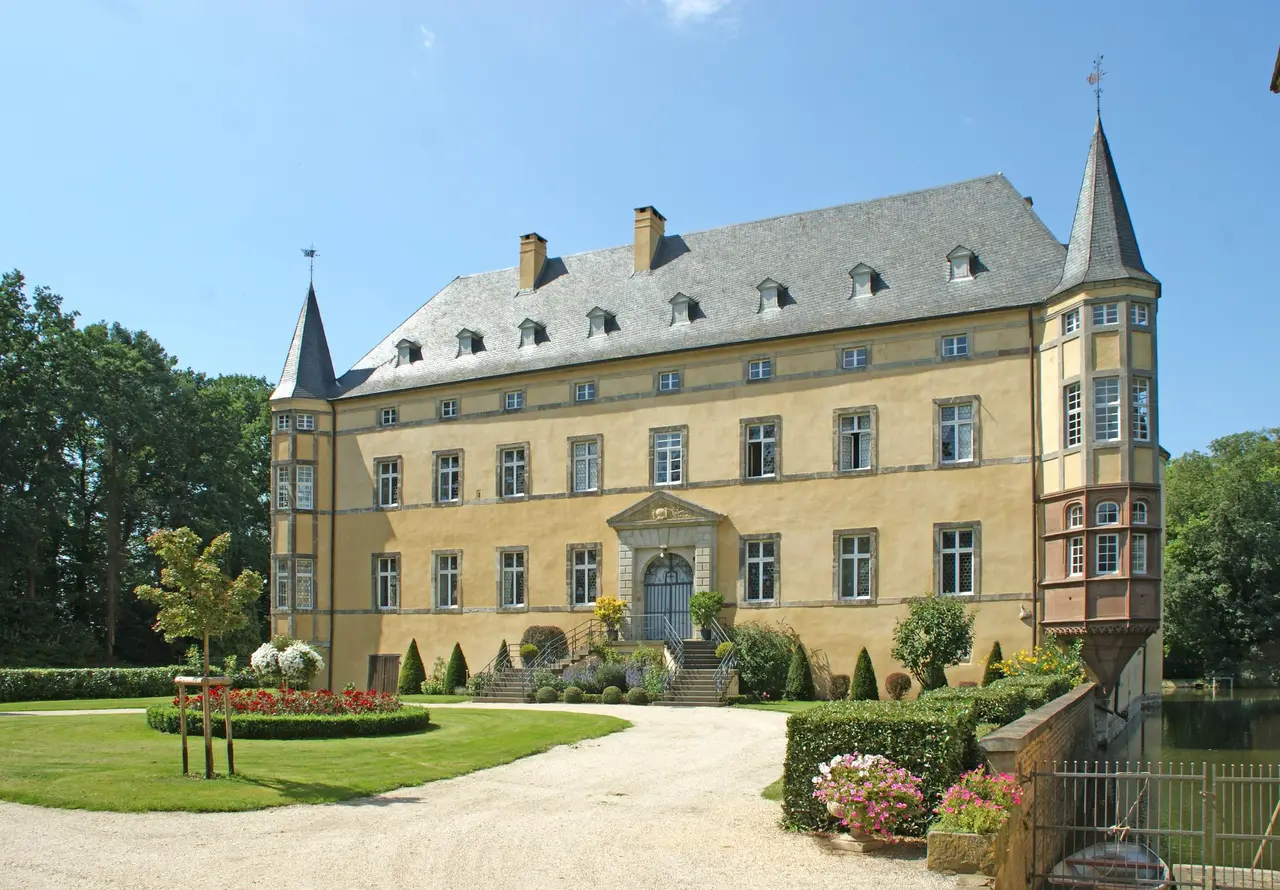 Historische Burg Adendorf mit Wassergraben und umgebenden Bäumen