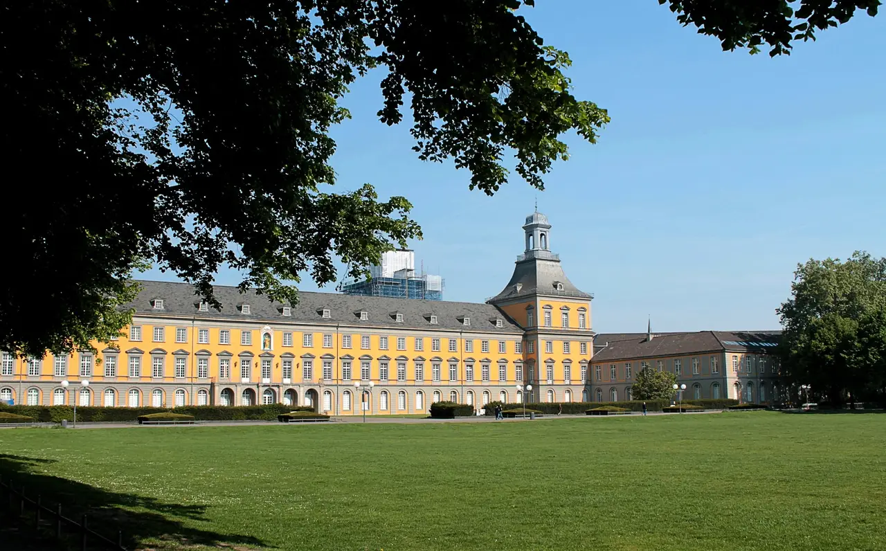 Grüne Hofgartenwiese vor dem gelben Universitätshauptgebäude in Bonn