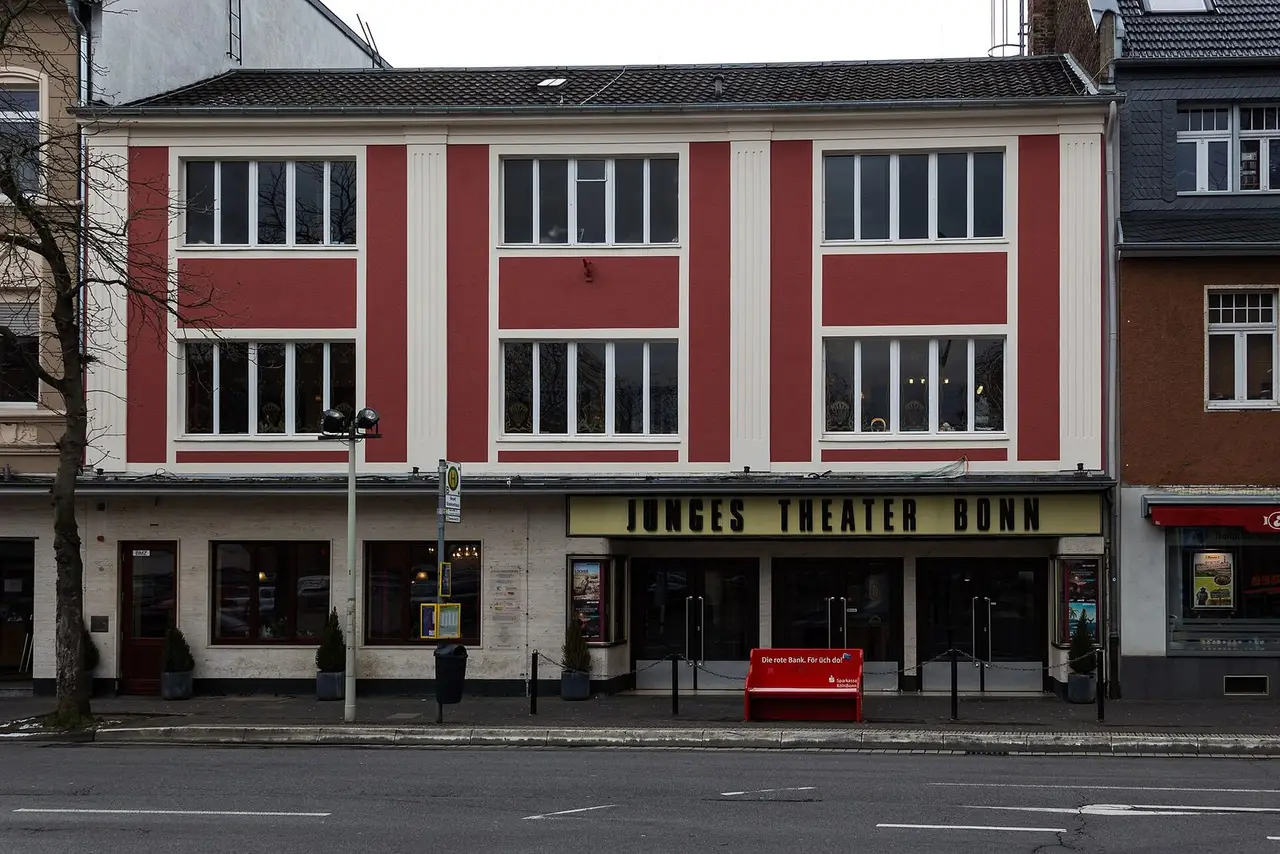 Rot-weiße Fassade des Jungen Theaters Bonn an der Hermannstraße mit Schriftzug über dem Eingang