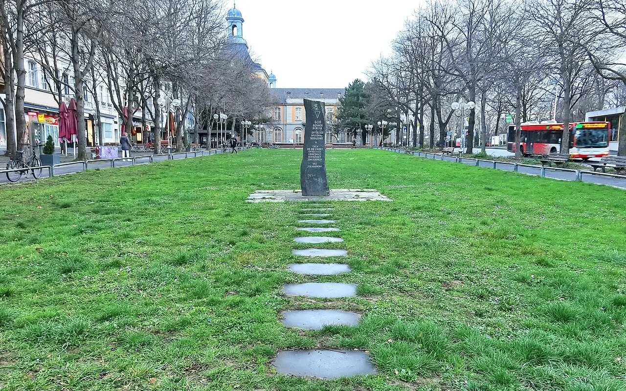 Mahnmal auf dem Kaiserplatz mit Steinplatten als Zugang über die Rasenfläche