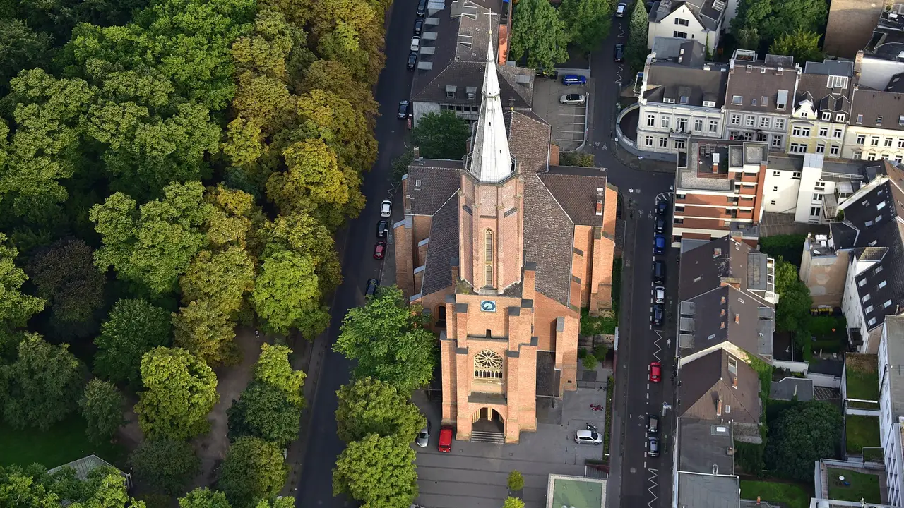 Luftaufnahme der neugotischen Kreuzkirche am Kaiserplatz in Bonn mit Backsteinfassade und Turmspitze