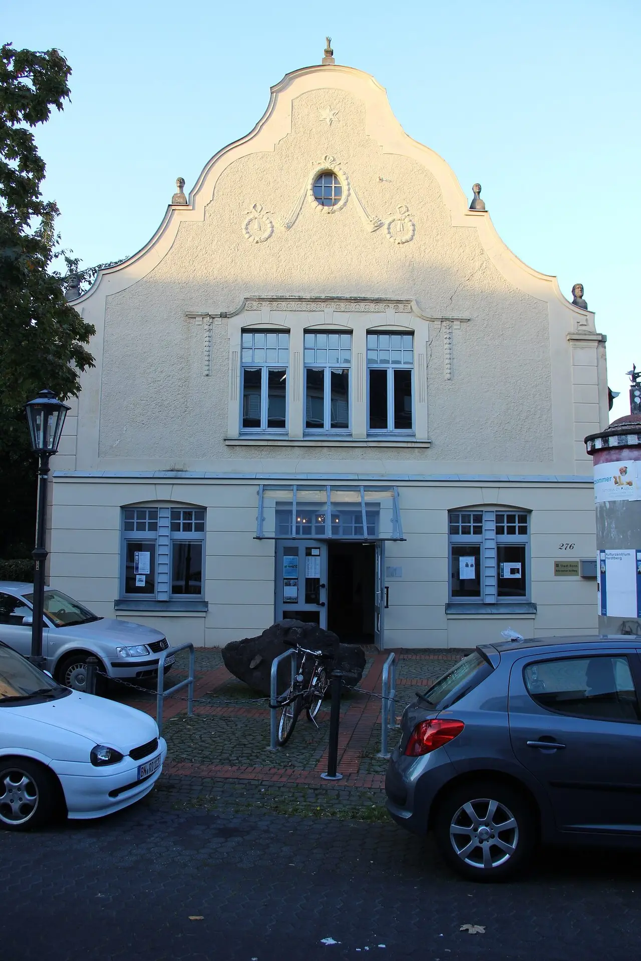 Hell verputzte Fassade mit geschwungenem Giebel und Eingang des Kulturzentrums Hardtberg an der Rochusstraße