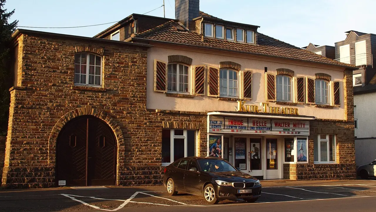 Bruchsteinbau des Kur-Theaters mit Torbogen und Kinoschriftzug in Hennef