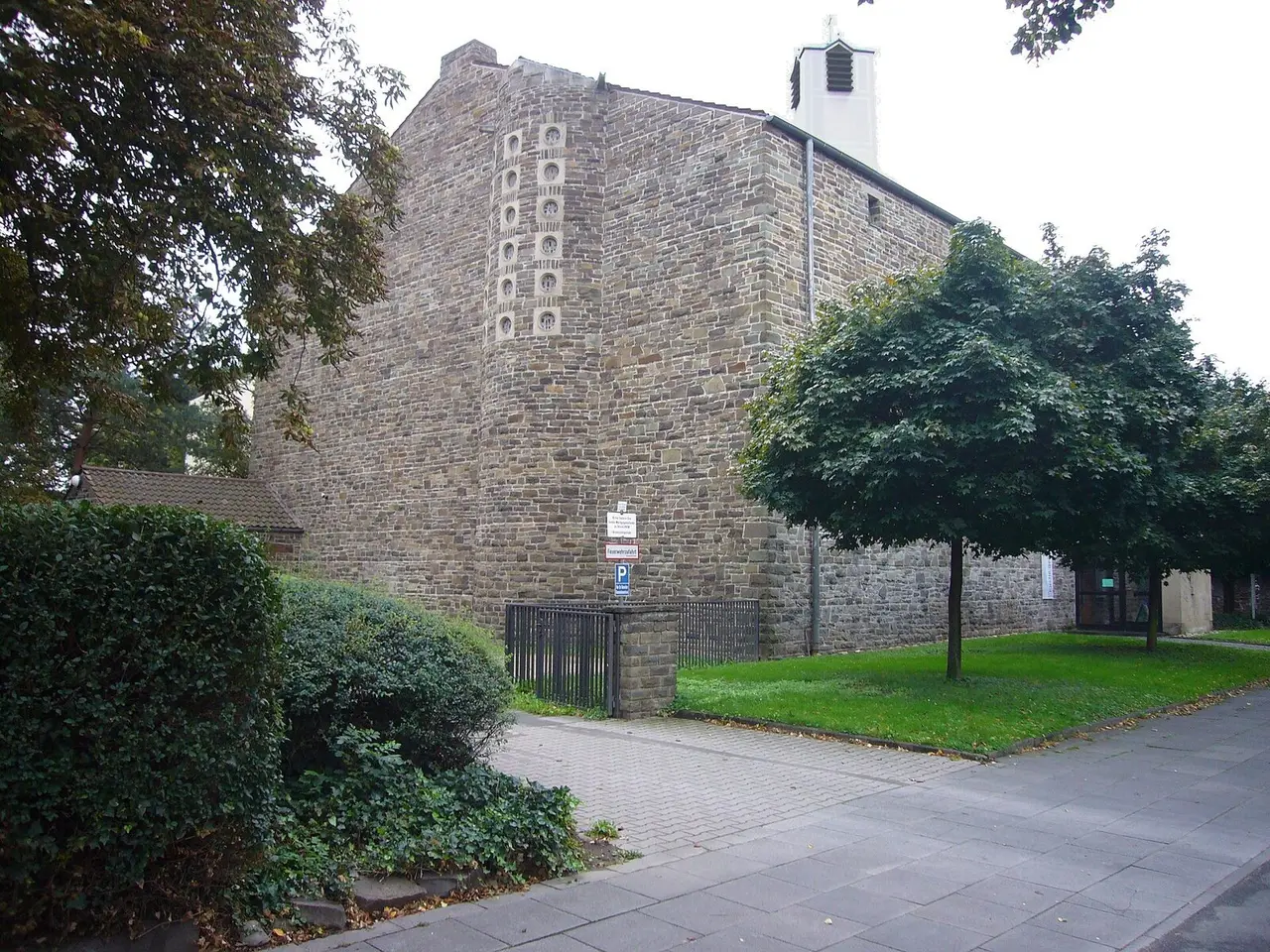 Bruchsteinfassade der Lukaskirche mit Laubbaum am Kaiser-Karl-Ring in Bonn