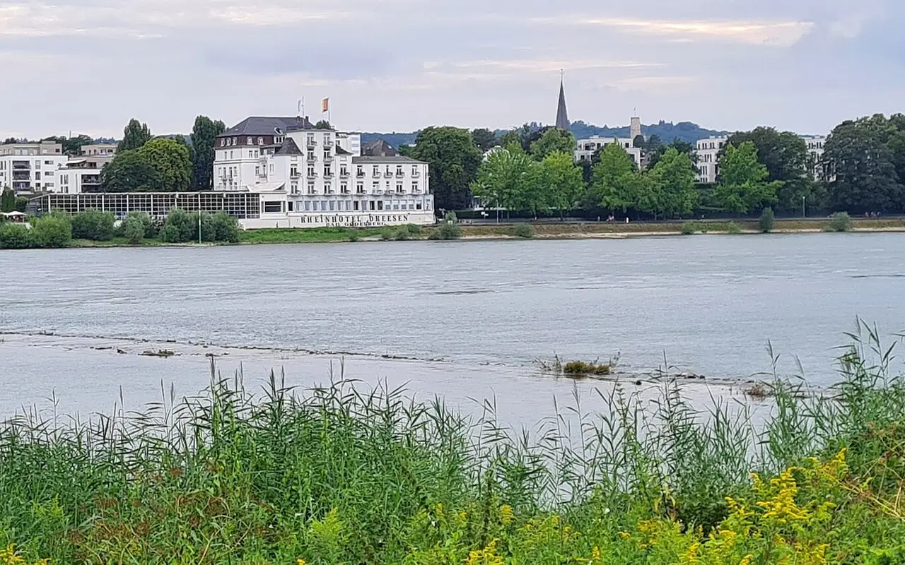 Blick über den Rhein auf die weiße Fassade des Rheinhotels Dreesen in Bonn-Rüngsdorf