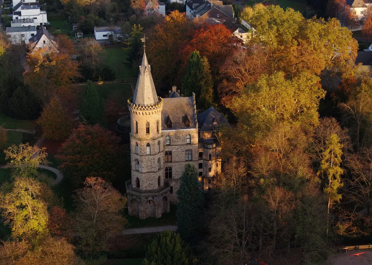 Schloss Sinzig mit Turm und historistischer Fassade hinter dem Park