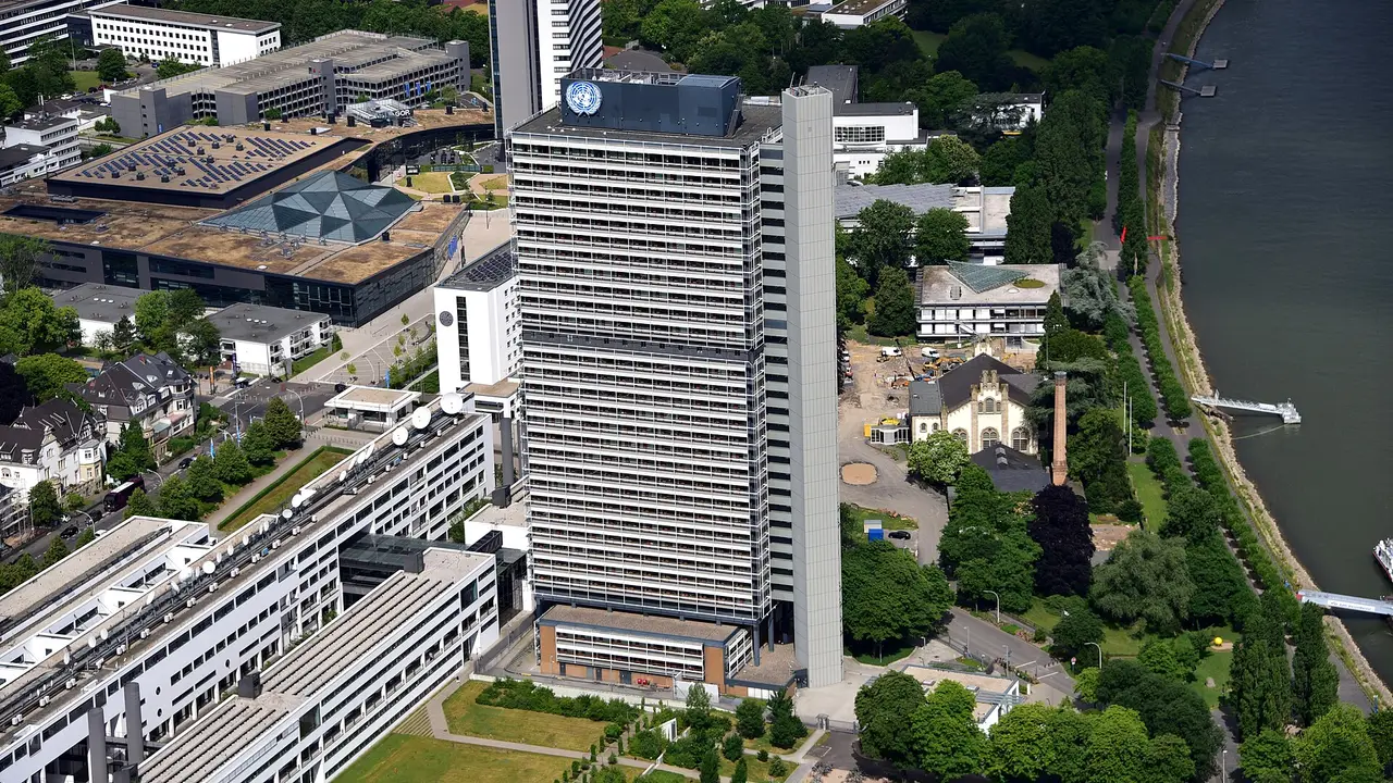 Luftaufnahme des Langen Eugen mit UN-Emblem auf dem UN Campus in Bonn, dahinter das WCCB und der Rhein