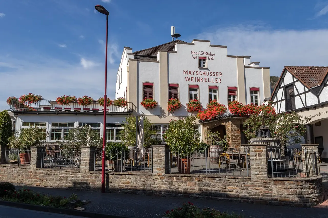 Giebelhaus des Mayschosser Weinkellers mit Blumenkästen und Terrasse an der Ahr-Rotweinstraße