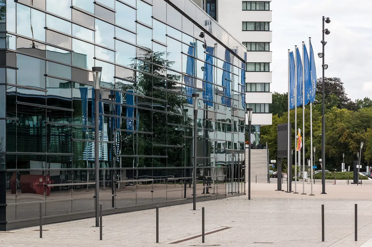Glasfassade des World Conference Center Bonn mit blauen Fahnen auf dem Vorplatz